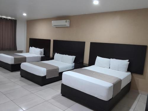 a hotel room with two beds with white pillows at Hotel Visión in Tuxpan de Rodríguez Cano