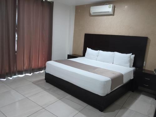 a bed in a hotel room with a large white bed at Hotel Visión in Tuxpan de Rodríguez Cano