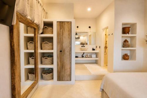 a bedroom with a door into a room with baskets at Maison de Reve - Boutique Guest House in Brisas de Zicatela