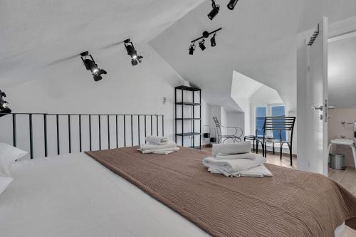 a white bedroom with a large bed with towels on it at Holiday Home Pelegrin in Brela
