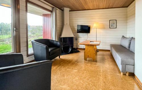 a living room with a couch and a table and a television at Degeberga Stugby in Degeberga