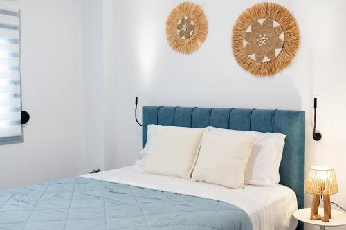 a bed with a blue headboard and white pillows at Celivine Seaside Residence in Faliraki
