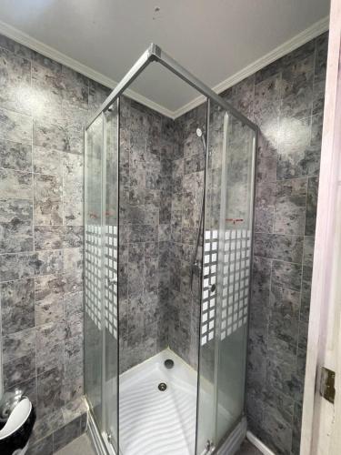 a shower with a glass enclosure in a bathroom at Hospedaje Oasis Modulares in Calama