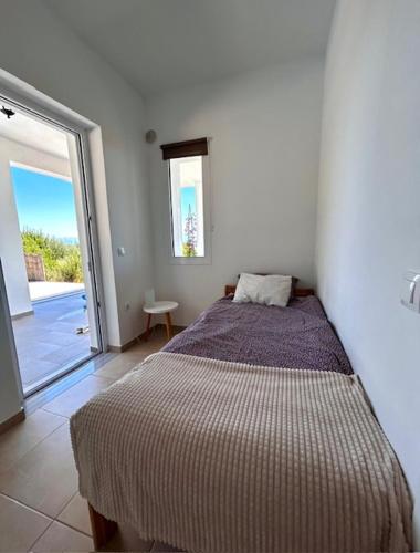 a bedroom with a bed and a sliding glass door at Villa Peony Koroni in Koroni