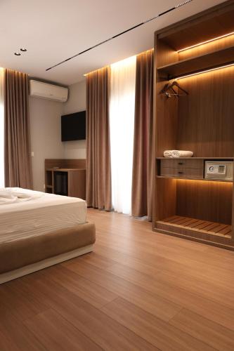 a hotel room with a bed and a television at Olivia Hotel in Durrës