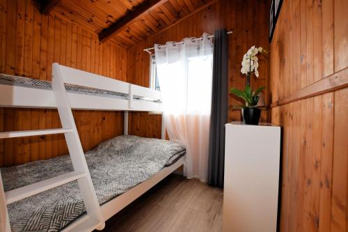 a bedroom with two bunk beds and a window at Domki Anetta in Dąbki