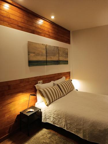 a bedroom with a bed and two paintings on the wall at Villa Régio Studio in Vila do Conde