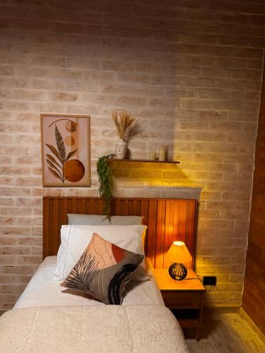 a bedroom with a bed with a wooden headboard at Vila do Sossego in São Bento do Sapucaí