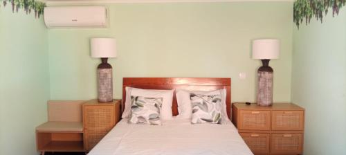 a bedroom with a bed with two lamps on it at Retiro dos Cedros - Quarto Vinhas in Fogueira