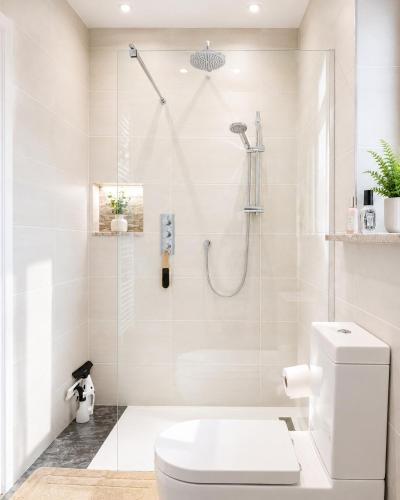 a white bathroom with a shower and a toilet at Ashwood Stays in Surbiton