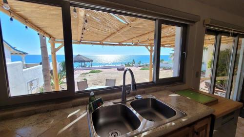 a kitchen with a sink and a view of the beach at Casa Evita in Puerto Peñasco