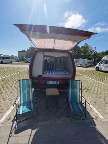 a vehicle with two chairs sitting in a parking lot at Retro Kamper Jastarnia in Jastarnia