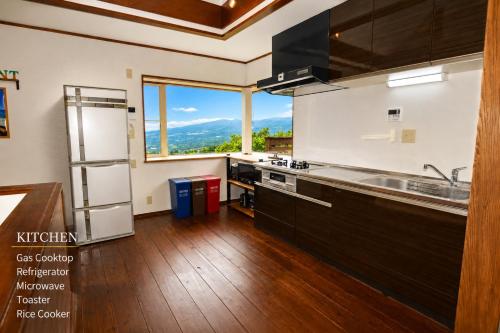 a kitchen with a sink and a large window at Ranked 1 in the Izu Mount Fuji from the villa in Izunokuni