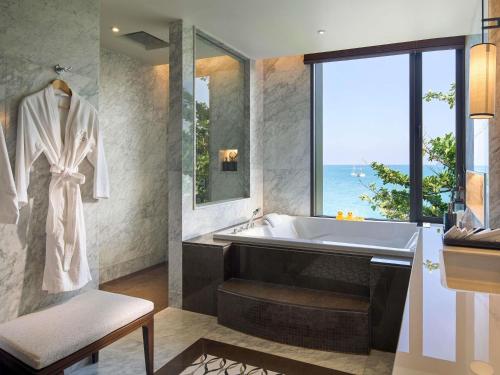 a bathroom with a bath tub and a large window at V Villas Phuket - MGallery Collection in Panwa Beach