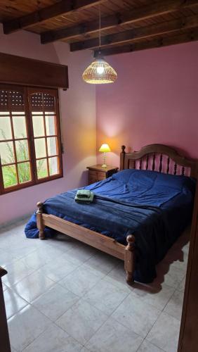 a bedroom with a large bed with a blue comforter at Casa Verde 3 in Carhué