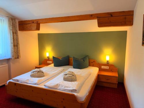 a bedroom with a large bed with two pillows at Residenz Dunza Hotel Garni in Bürserberg