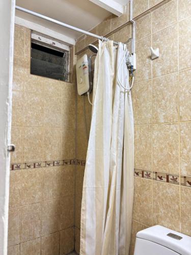 a bathroom with a shower curtain and a toilet at El Duke Kahanamoku surf hostel in Pacasmayo
