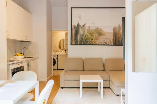 a living room with a couch and a table at NEMIRSETA FOREST Apartments in Palanga