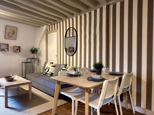 a dining room with a table and a bed at Hypercentre Fontainebleau -Tout confort 2 chambres in Fontainebleau