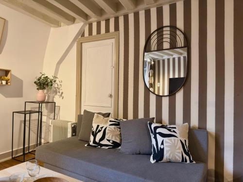 a living room with a blue couch and a mirror at Hypercentre Fontainebleau -Tout confort 2 chambres in Fontainebleau