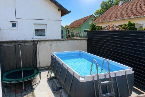 a hot tub on a patio with a chair and a table at Apartman Lucija kuća za odmor in Vukovar