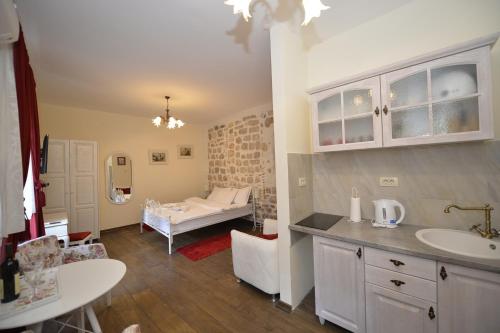ein Badezimmer mit Waschbecken und ein Bett in einem Zimmer in der Unterkunft Palazzo Max and Alex Apartments in Kotor
