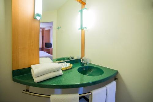 a bathroom with a green sink and a mirror at Hotel Iris Guadalajara in Guadalajara