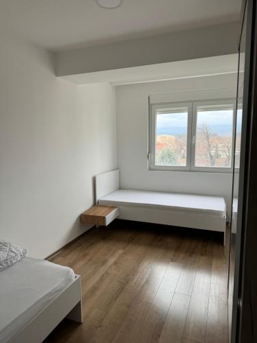 a white room with a bench in front of a window at Vila Manuela in Gevgelija
