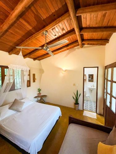a bedroom with a white bed in a room with wooden ceilings at Kallpa B&B in Palomino