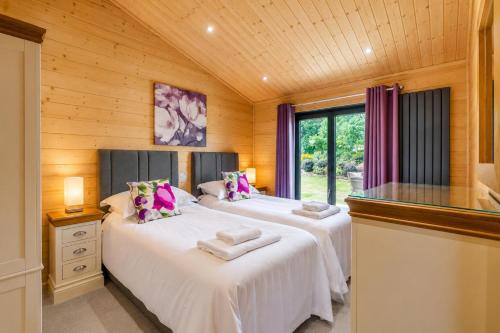 two beds in a room with wooden walls at 2 Bed in Nafferton oc-p31955 in Nafferton
