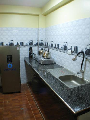 a kitchen with a counter with a sink and a refrigerator at Imasmari Wasi in Pisac