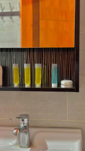 a shelf above a sink with four glasses on it at WADI RUM NASA lUXURY BUBBLE in Wadi Rum
