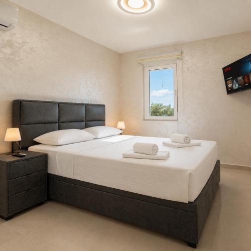 a bedroom with a large bed with two towels on it at Dorado Apartments in Kavač
