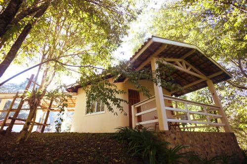 a small house in the middle of a forest at Pousada Highland in Santo Antônio do Pinhal
