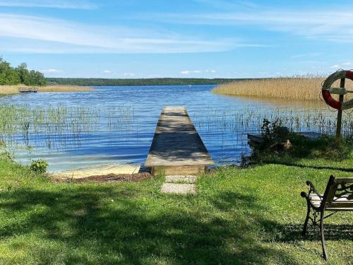 a bench sitting next to a dock on a lake at 4 person holiday home in Tibro in Tibro