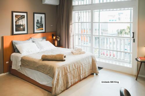 a bedroom with a bed and a large window at Rio Branco 688 - Hospedagem Premium in Santa Maria