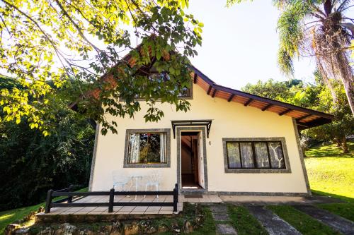 a small house with two chairs in front of it at Pousada Highland in Santo Antônio do Pinhal