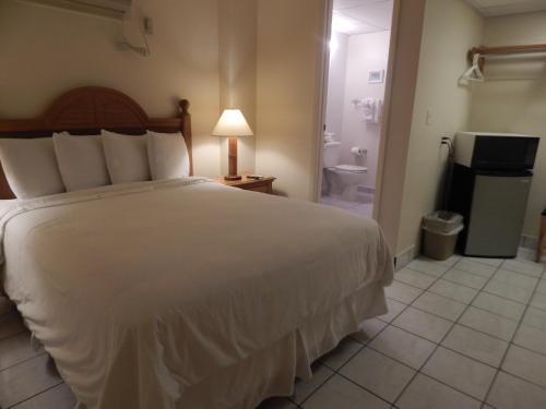 a bedroom with a white bed and a bathroom at Parmer's Resort in Little Torch Key
