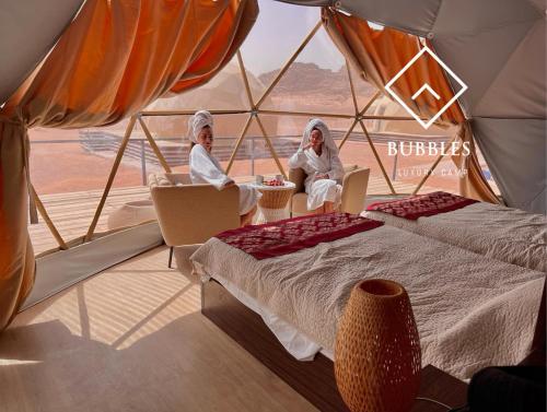 two women sitting in a tent in the desert at BUBBLES LUXURY CAMp in Wadi Rum