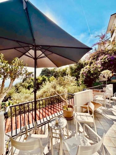 a patio with an umbrella and chairs and tables at Villa Nemanja in Sveti Stefan