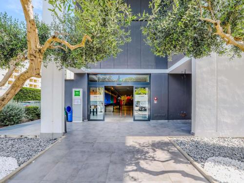 an entrance to a building with trees in the foreground at Ibis Styles Roma Aurelia in Rome