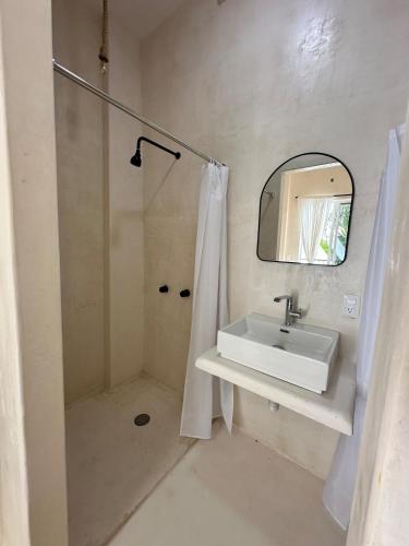 a bathroom with a sink and a shower with a mirror at Patio Canarias Chacala Suites Pet-Friendly in Chacala