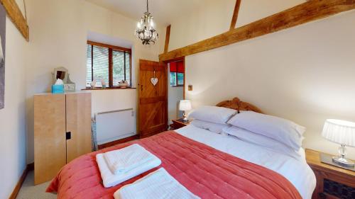 a bedroom with a large bed with white pillows at The Byre in Banbury