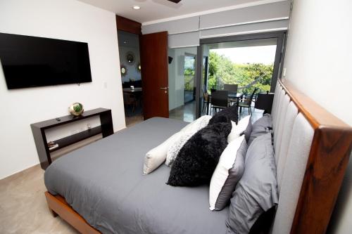 a bedroom with a bed with a flat screen tv at Depa MAJUM Playa del Carmen in Playa del Carmen