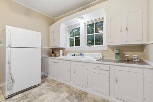 a kitchen with white cabinets and a white refrigerator at Cozy 1BR Cottage w Kitchen & Laundry in Lafayette