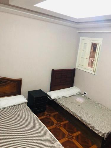 a room with two beds and a window at Maria Apartment in Alexandria