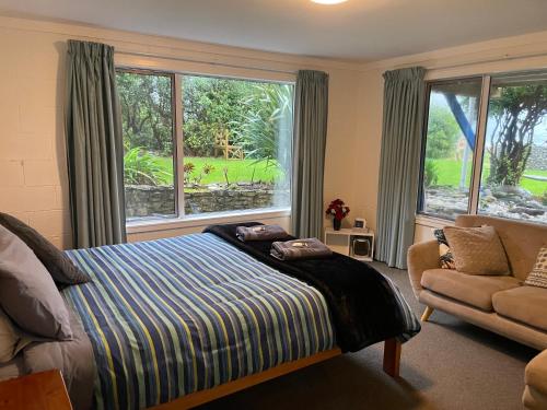 a bedroom with a bed and a large window at Punakaiki Beach Hostel in Punakaiki