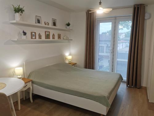a bedroom with a bed and a table and a window at Happy Home2 in Cahul