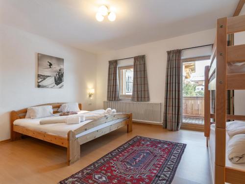 a bedroom with two beds and a rug at Dorf30 in Going am Wilden Kaiser