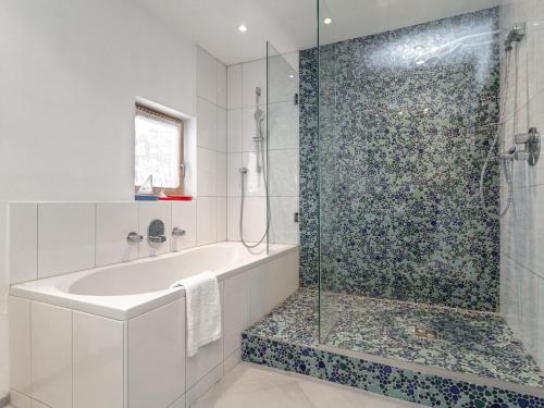 a bathroom with a tub and a glass shower at Dorf30 in Going am Wilden Kaiser